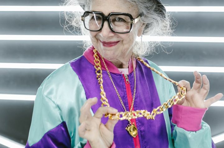 woman in purple jacket with gold necklace